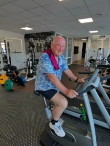 Algemene fysiotherapie: oudere man fietst op een hometrainer in de oefenzaal van TopFysio Leeuwarden. 