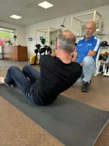 Patiënt oefent bij rugpijn onder begeleiding van een fysiotherapeut