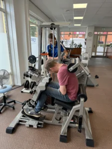 Patiënt traint de onderrug op OriGENE onder begeleiding van een fysiotherapeut